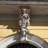Foto 12. Il portone d�ingresso, in ferro, � racchiuso da una cornice di pietra sulla cui chiave di volta spicca una testa femminile con drappeggi e fiori (foto di Antonio Caradonna)